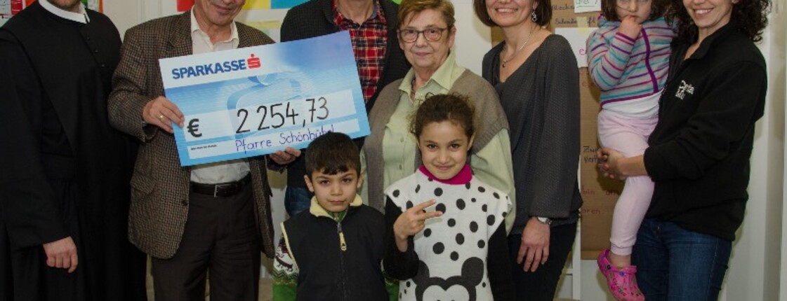 Spendenübergabe Pfarre Schönbühel Frater Alois, Caritasdirektor Friedrich Schuhböck, Ignaz Röster, Christine Prinz und Martina Bischof (alle Pfarrgemeinderat Schönbühel) und Caritas Leiterin in Melk Beate Zinner mit jungen Bewohnerinnen im Containerdorf.