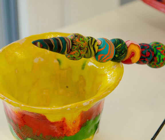 Werkstatt Loosdorf Produkt bunte Tonschale mit einem Stab mit bunt bemalten Tonkugeln