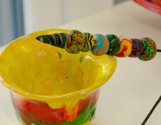 Werkstatt Loosdorf Produkt bunte Tonschale mit einem Stab mit bunt bemalten Tonkugeln