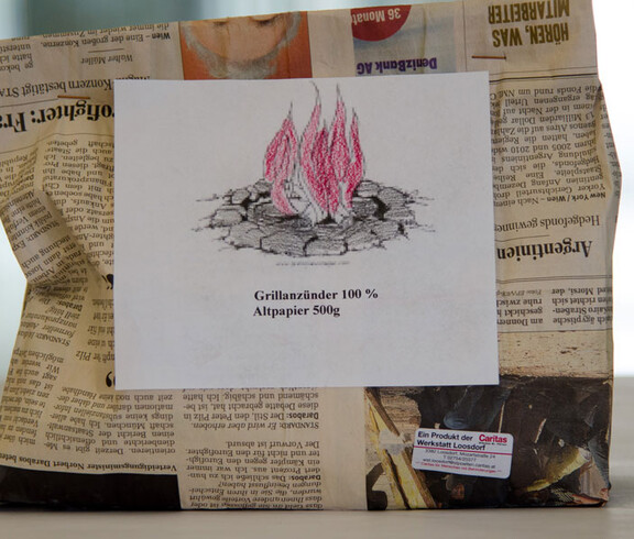 Werkstatt Loosdorf Produkt Grillanzünder in einer Verpackung aus altem Zeitungspapier