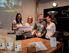 Eine youngCaritas-Mitarbeiterin im Kaffee-Campus Krems mit drei Teilnehmern