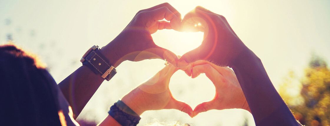 beautiful photo of a couple making heart shapes with their hands toned with a retro vintage instagram filter