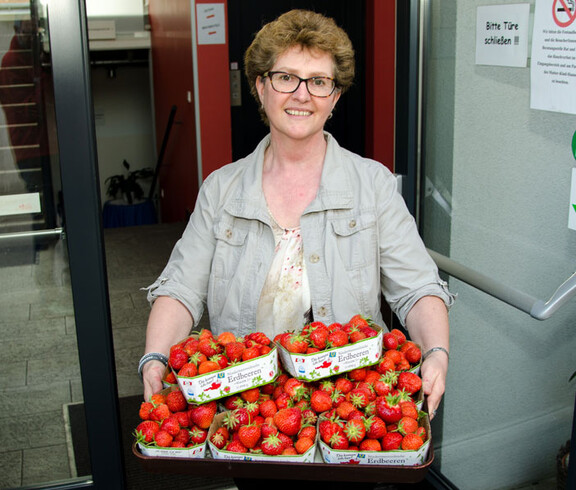 Caritas-Mitarbeiterin mit frischen Erdbeeren