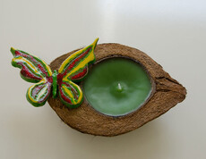 Werkstatt Loosdorf Produkt eine grüne Kerze in einer Feigenschale mit einem grünen Schmetterling 
