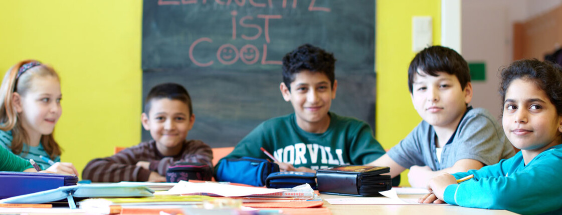 Lerncafe Caritas St. Pölten Schulkinder sitzen an einem Tisch und machen Aufgabe