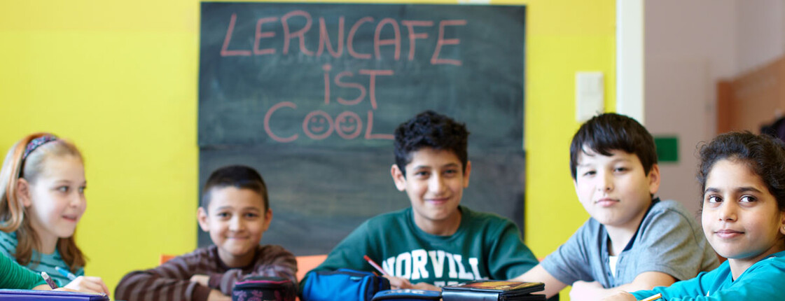 Lerncafe Caritas St. Pölten Schulkinder sitzen an einem Tisch und machen Aufgabe