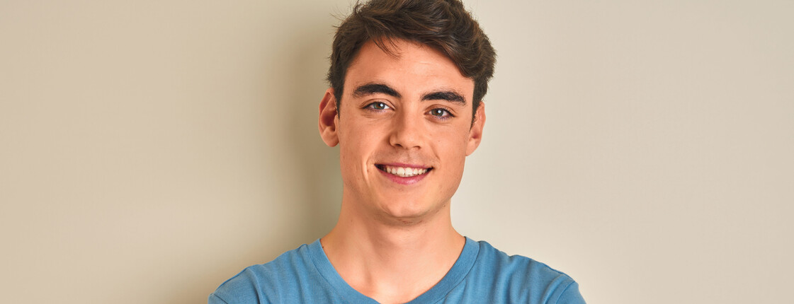 Teenager boy wearing casual t-shirt standing over isolated background happy face smiling with crossed arms looking at the camera. Positive person.