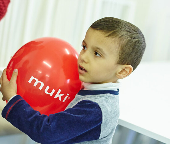 Ein junger Bewohner der Containerunterkunft in Melk spielt mit einem Luftballon