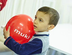 Ein junger Bewohner der Containerunterkunft in Melk spielt mit einem Luftballon