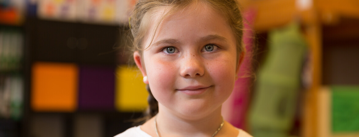 Portrait eines Mädchens mit einer Halskette in einem Kindergarten.