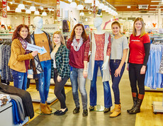 Eine youngCaritas-Mitarbeiterin in der C&A-Filiale in Ybbs an der Donau mit den jngen Teilnehmerinnen des "youngHeroes Day" und zwei Schaufensterpuppen
