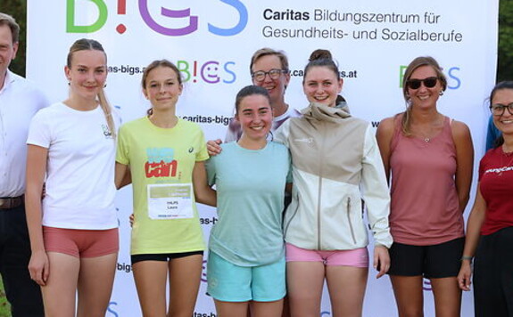 Caritas Bildungszentrum für Gesundheits- und Sozialberufe: Läuferinnen und Betreuerinnen posieren vor Banner