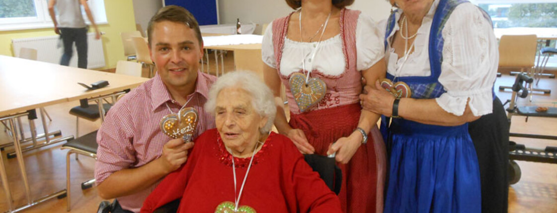 Mitarbeiter, Heimleiterin und Bewohnerinnen mit Lebkuchenherz