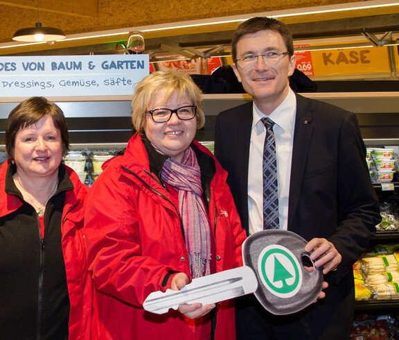 Im Spar Gruppenfoto der Caritas-Mitarbeitern und dem Sparchef mit dem symbolischen Schlüssel für das Caritas-Auto