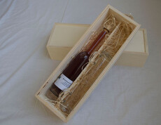 Eine Flasche Brombeerlikör mit zwei Gläsern in einer Schachtel
