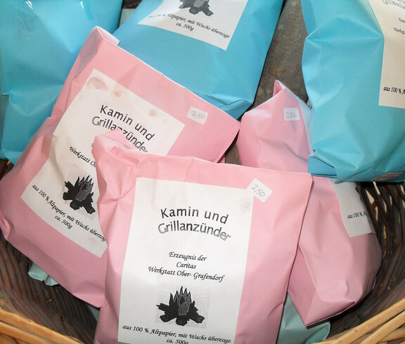 Werkstatt Obergrafendorf Produkt Grillanzünder in rosa und blauen Verpackungen