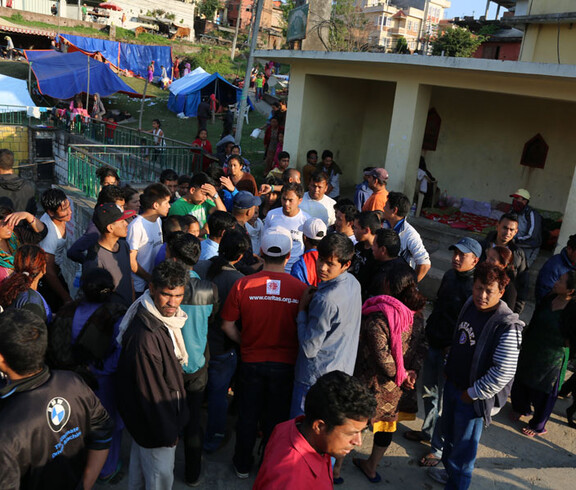 Eine Gruppe von Einwohnern aus Nepal stehen zusammen, hinter ihnen sieht man viele Zelte.