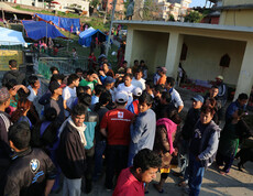 Eine Gruppe von Einwohnern aus Nepal stehen zusammen, hinter ihnen sieht man viele Zelte.
