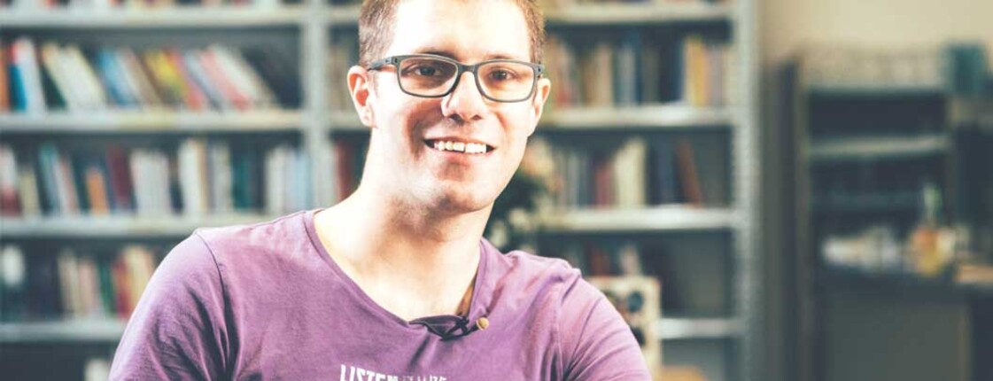 Junger Mann sitzt am Tisch