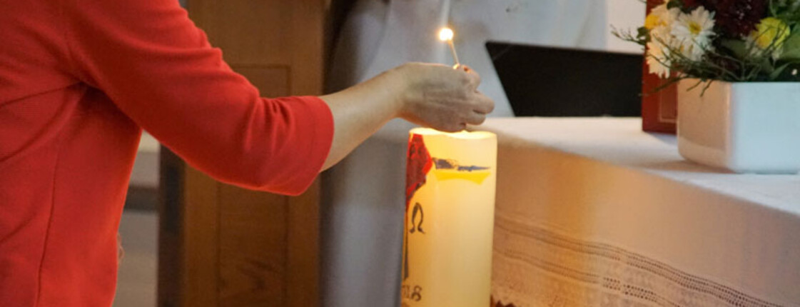Angehörige zündet Kerze an