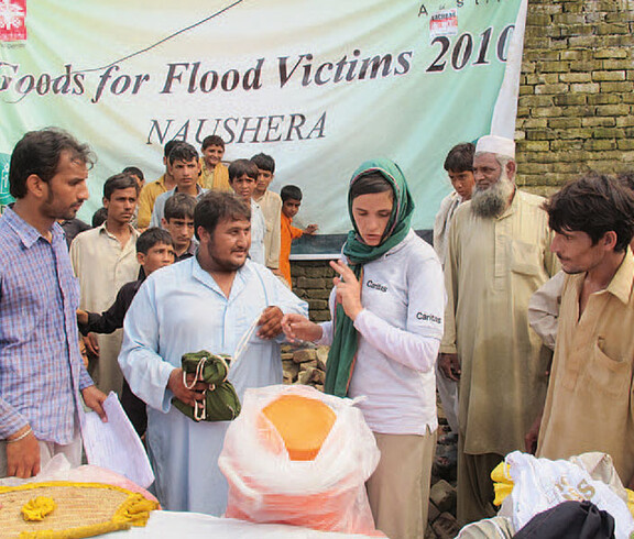 Caritas-Mitarbeiterin in Pakistan bei Spendenausgabe der Flutopfer von 2010