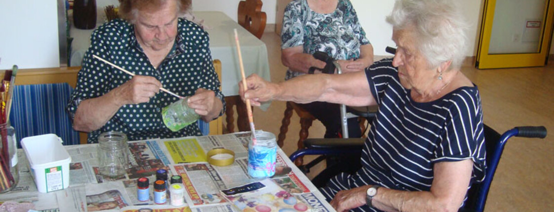 Zwei Bewohnerinnen bemalen die Gläser