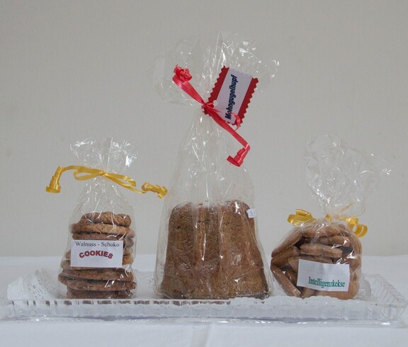 Drei Packungen verschiedenem Gebäck, ganz links Schoko-Walnuss Cookies, daneben ein Kuchen und ganz rechts eine Packung Intelligenzkekse.