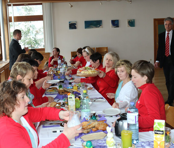 Viele Menschen sitzen an einem Tisch und essen