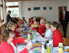 Viele Menschen sitzen an einem Tisch und essen