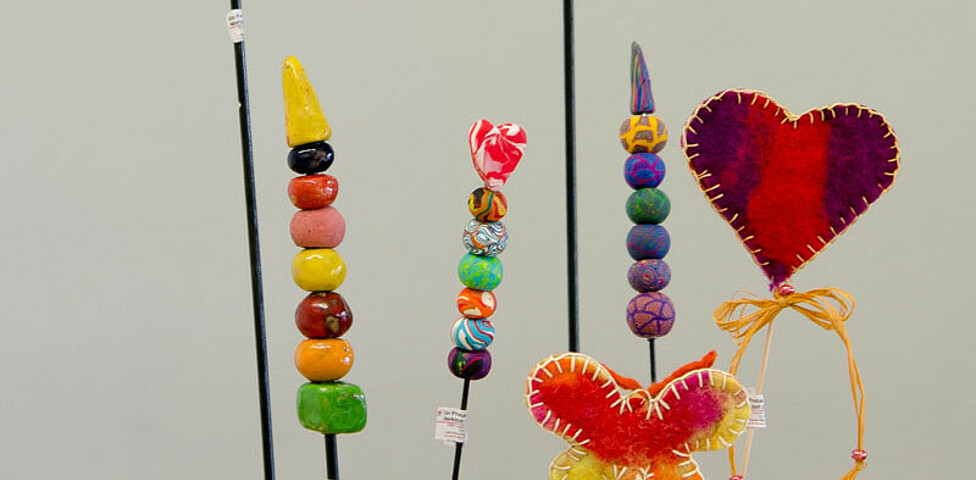 Werkstatt Loosdorf Produkt Deko aus bunten Tonkugeln und einem Herz und einem Schmetterling aus buntem Filz