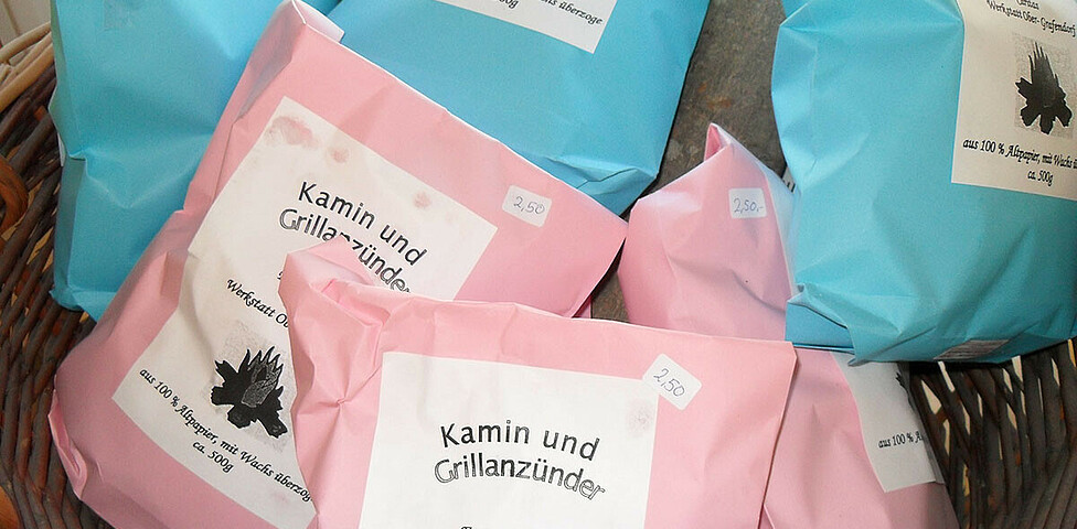 Werkstatt Obergrafendorf Produkt Grillanzünder in rosa und blauen Verpackungen