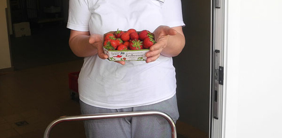 Mitarbeiterin des Erdbeerproduzenten Huber mit vielen frischen Erdbeerem