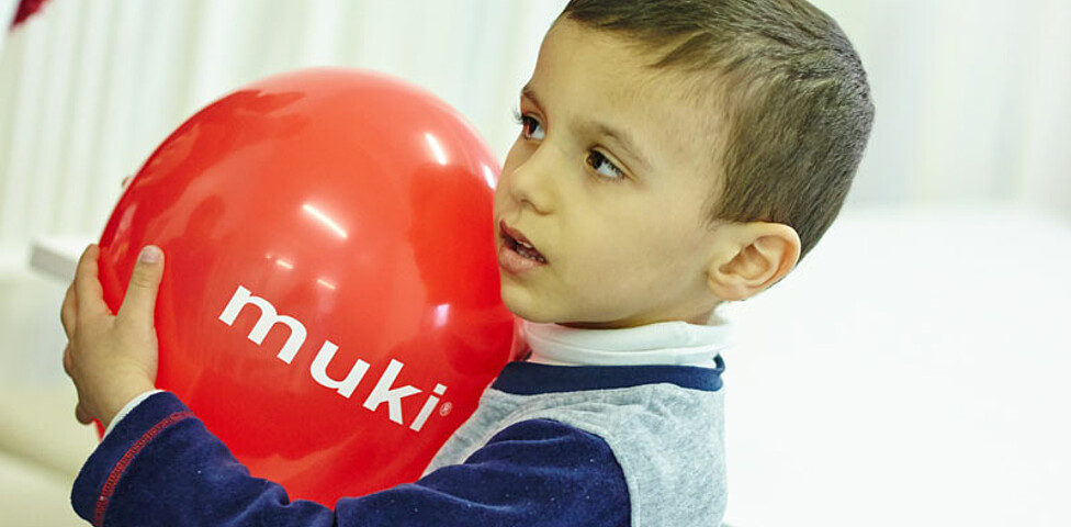 Ein junger Bewohner der Containerunterkunft in Melk spielt mit einem Luftballon