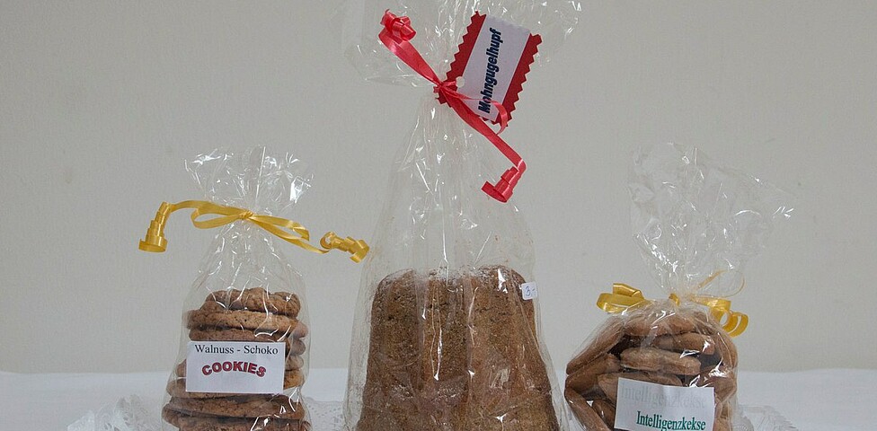 Drei Packungen verschiedenem Gebäck, ganz links Schoko-Walnuss Cookies, daneben ein Kuchen und ganz rechts eine Packung Intelligenzkekse.