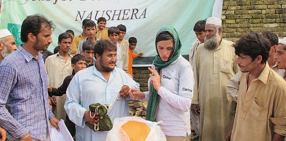 Caritas-Mitarbeiterin in Pakistan bei Spendenausgabe der Flutopfer von 2010
