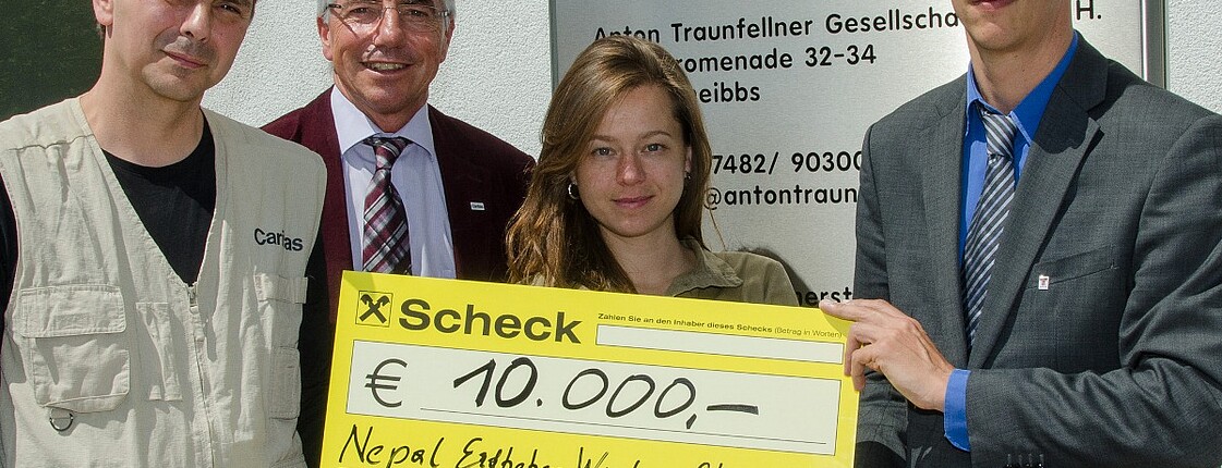 Spendenübergabe der Firma Traunfellner. Geschäftsführung übergibt Spendenscheck an Caritasmitarbeiter Andreas Zinggl.